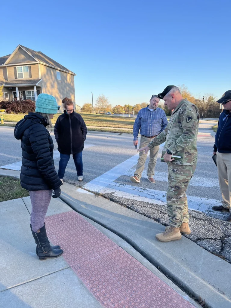 Inspectors reviewing a residential sidewalk curb ramp to ensure compliance with city bylaws and accessibility standards