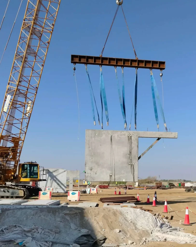Precast concrete wall panel installation using crane on a commercial construction site