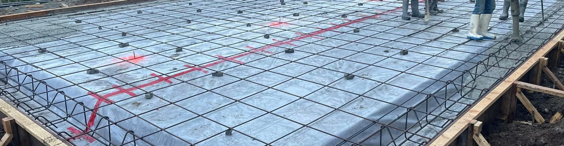 Contractor assessing soil conditions and lot grading before garage pad installation