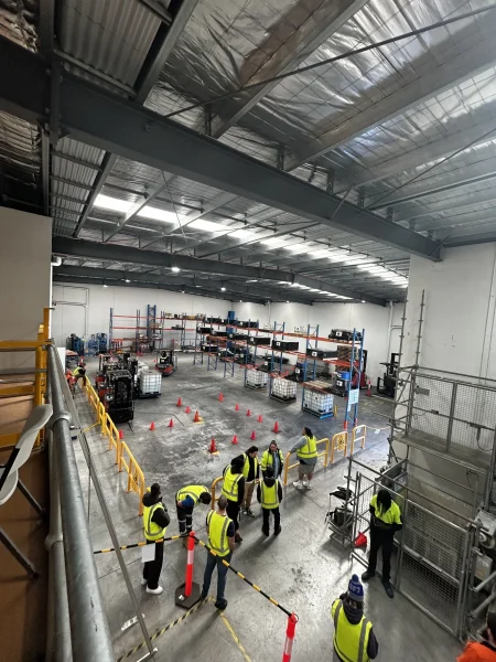 Industrial warehouse floor made of polished concrete with staff inspecting the surface and equipment during training